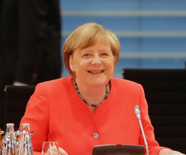 German Chancellor Angela Merkel is seen in a coral suit at a cabinet meeting