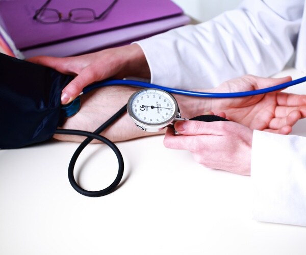 healthcare worker taking blood pressure of patient