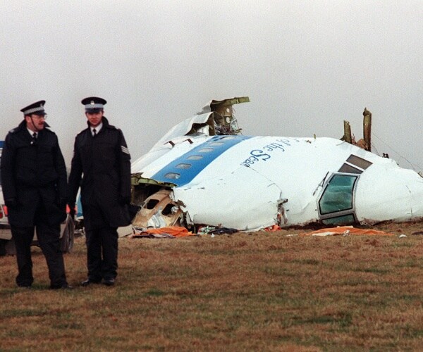 policemen stand in front of crashed plane 