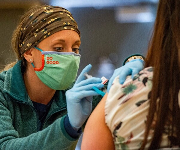 medical worker administers coronavirus vaccine