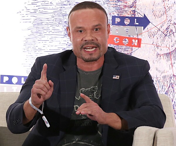 Dan Bongino speaks on stage during a conference