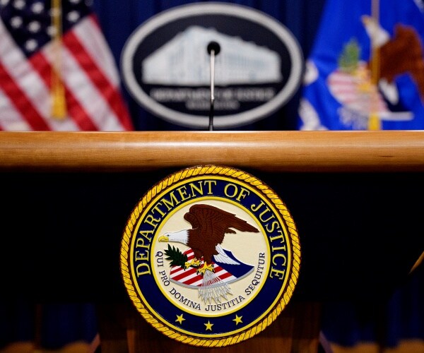 A Justice Department employee claims she was fired after DOJ learned her husband had developed a pho...