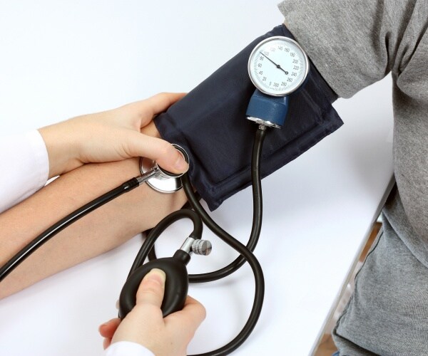 person getting their blood pressure checked by a doctor