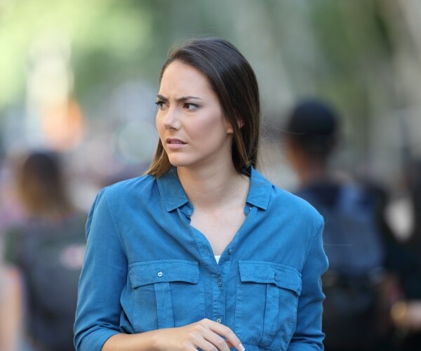 woman out on a public street looking scared and anxious