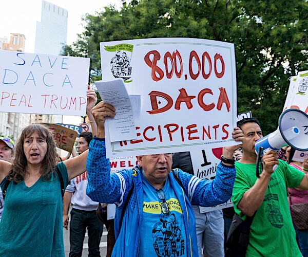 protesters holds signs to save daca