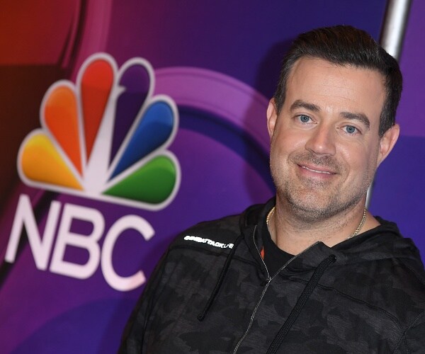 carson daily stands in front of nbc logo