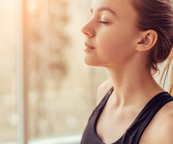 side view of young woman breathing, eyes closed
