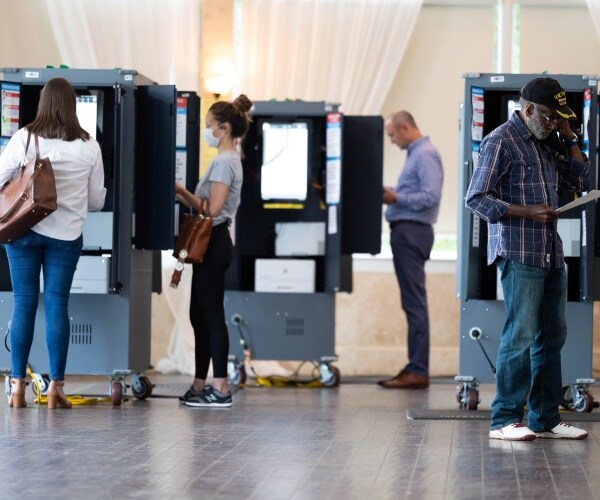 voters checks printed ballots during an election