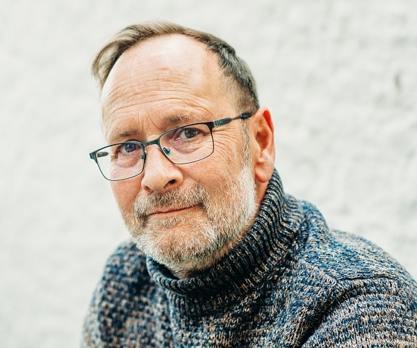 old man wearing turtleneck and glasses