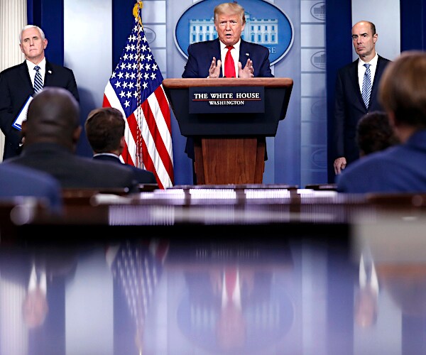 president donald trump stands before a media throng during a coronavirus task force daily briefing