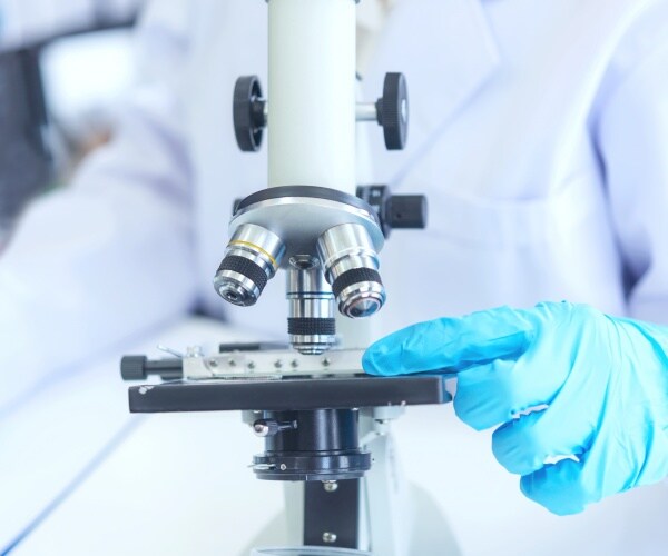 scientist looking in microscope