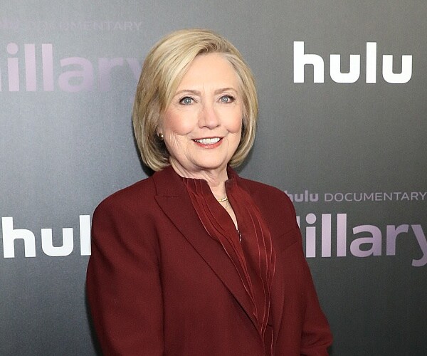 hillary clinton stands on red carpet