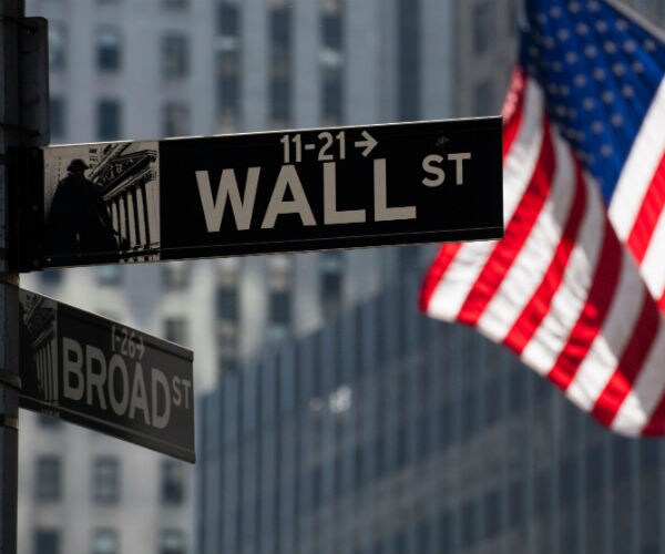 street signs at the corner of wall and broad streets in new york city