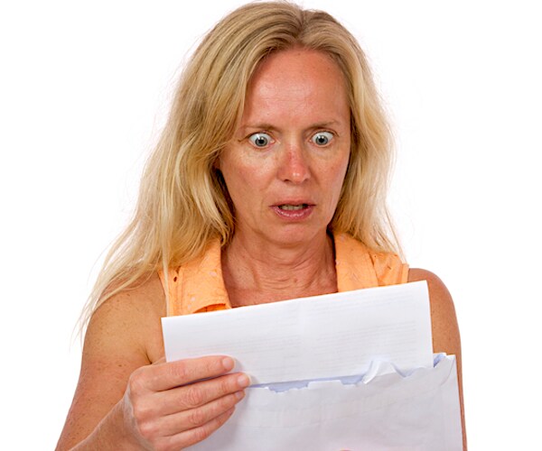 a woman is shocking to read the contents of a mailed medical bill