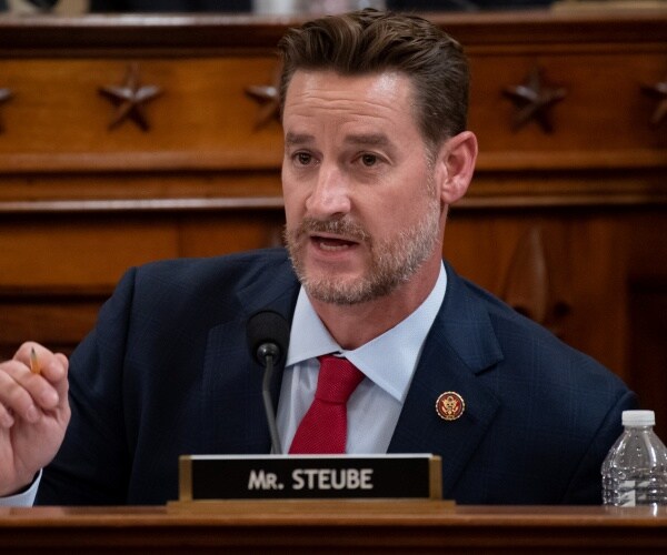 steube in a suit and red tie speaking at a hearing