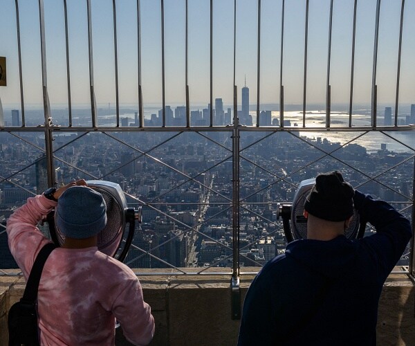 tourists look out from empire state building