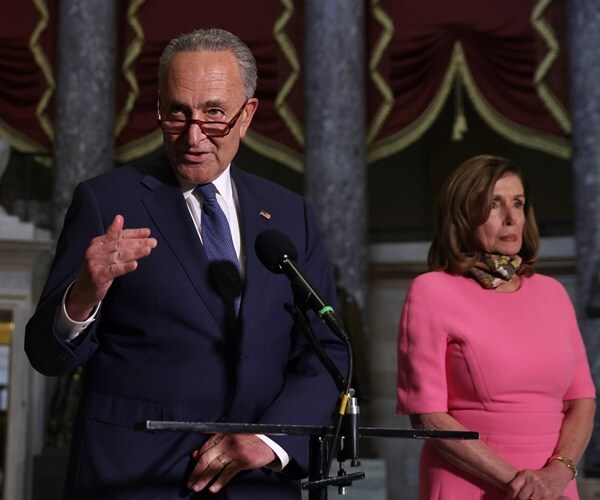 chuck schumer speaks to the press as nancy pelosi stands beside him