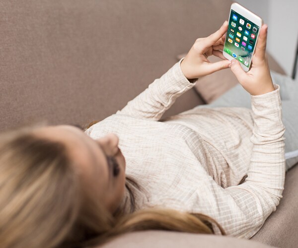 a woman using a cell phone on a couch