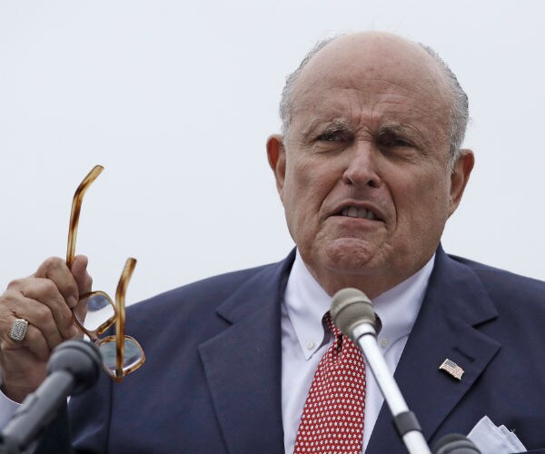 rudy giuliani takes off his glasses during a news conference between answering questions