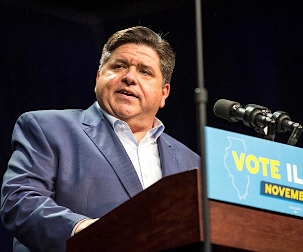 democrat billionaire jb pritzker looks to his right while pausing during a campaign rally speech