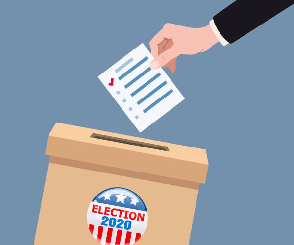 a hand putting a ballot into a box labeled election 2020