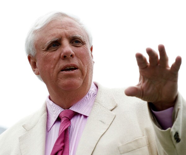 jim justice is shown in a white suite jacket with a pink shirt and neck tie