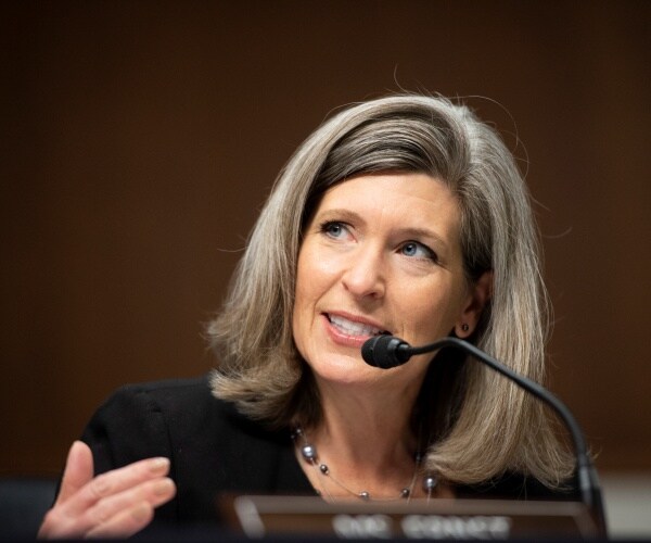 ernst in a black top and beaded necklace