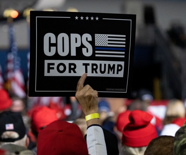 man holding cops for trump sign