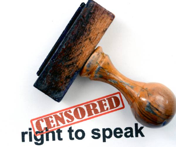 the words free speech on a piece of paper with censored stamped on top