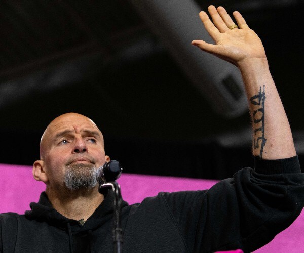 fetterman waving to the crowd with a tired look on his face