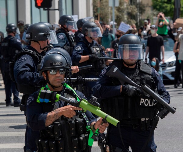 police officers in los angeles hold guns that fire rubber bullets