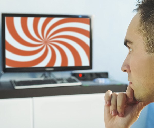 a man watches television with a hypnotizing image on it