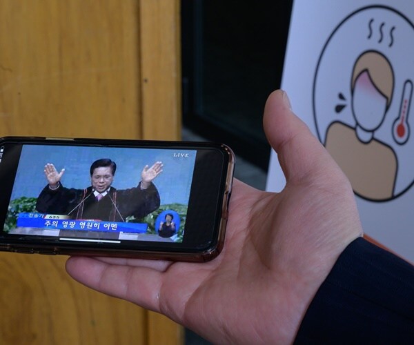 a pastor's service is livestreamed on a phone