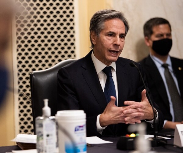 tony blinken speaks seated at a table
