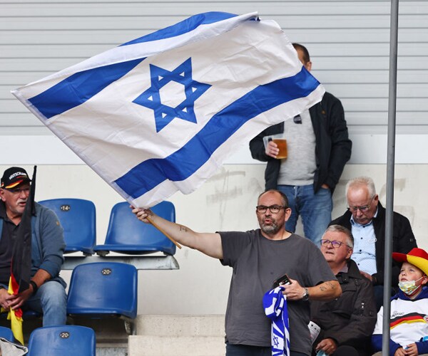 a soccer fan waves an israel flag