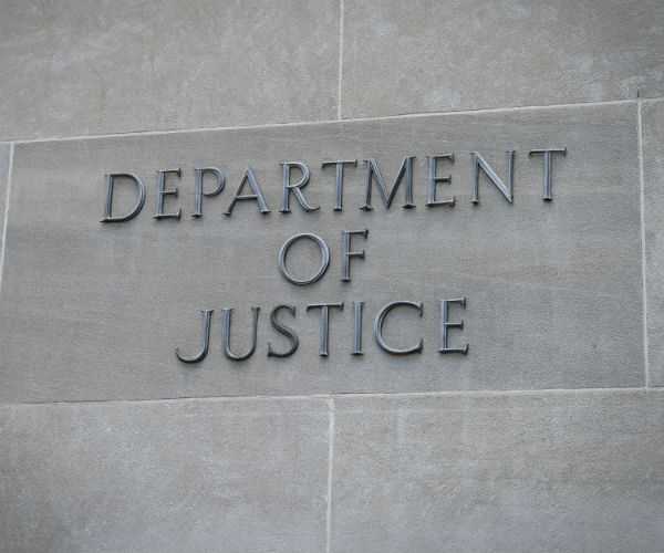 A sign on the DOJ building is shown.