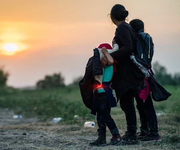 migrant family watches sunset