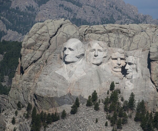 mount rushmore is shown with other mountain the background and four faces carved into the rock