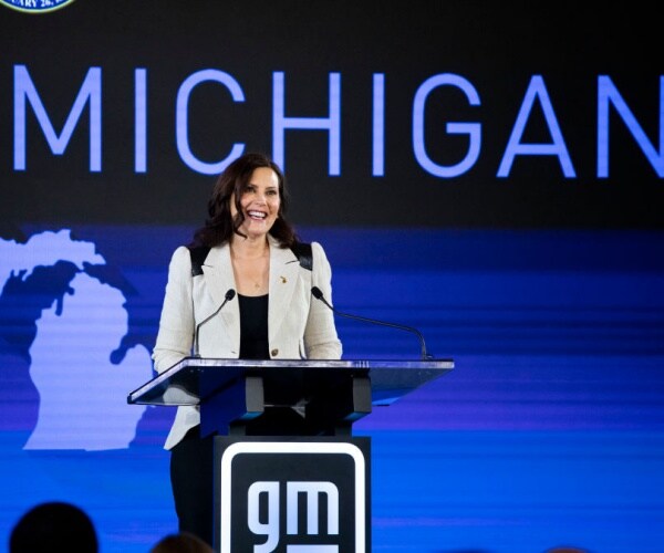 Gretchen Whitmer smiles from behind a podium