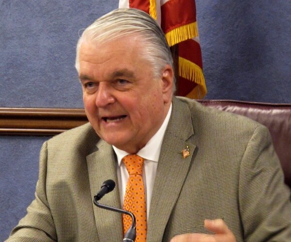 sisolak in a light gray suit and orange tie