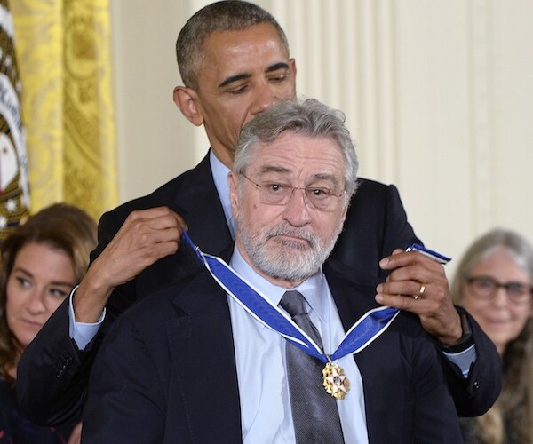 actor robert deniro stands with his back to barack obama, who drapes an award around his neck
