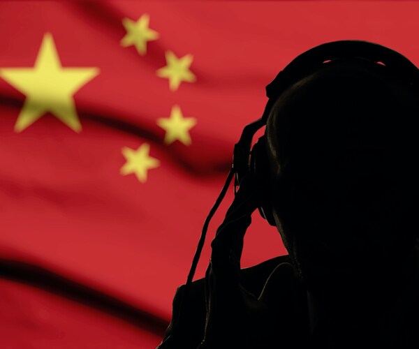 a man in the foreground shadows of a chinese flag