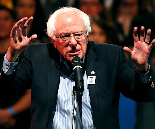 bernie sanders raises both hands up like a bear in attack mode