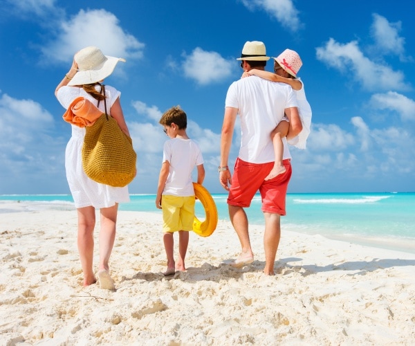 family walking along the beach in summer