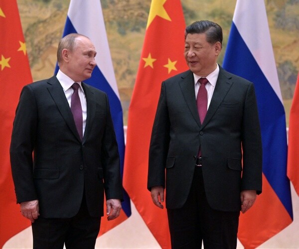 vladimir putin and xi jinping stand next to one another