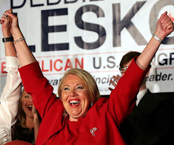 debbie lesko raises both hands in victory after a campaign win