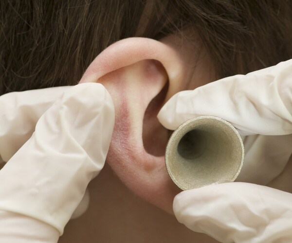 close up of gloved hands examining an ear