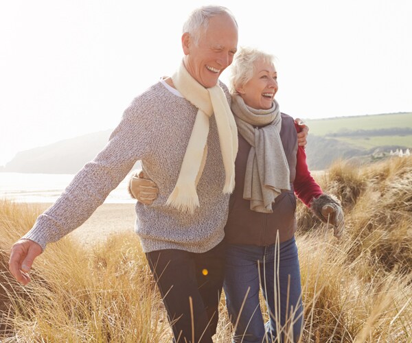 a senior couple walking near the beach