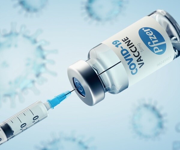 Pfizer vial with COVID-19 vaccine and a syringe in the vial