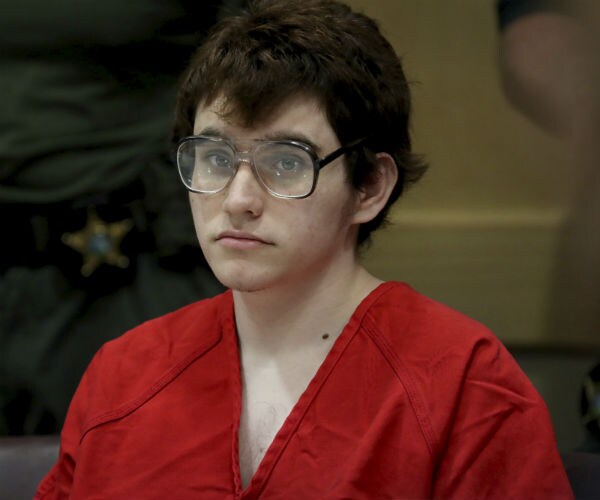 nikolas cruz iss shown in court with red jumpsuit on and black eyeglasses